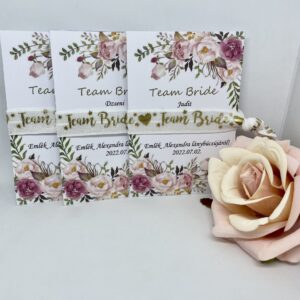 TEAM BRIDE fehér, arany felirattal, virágos kártyával lánybúcsús karkötő