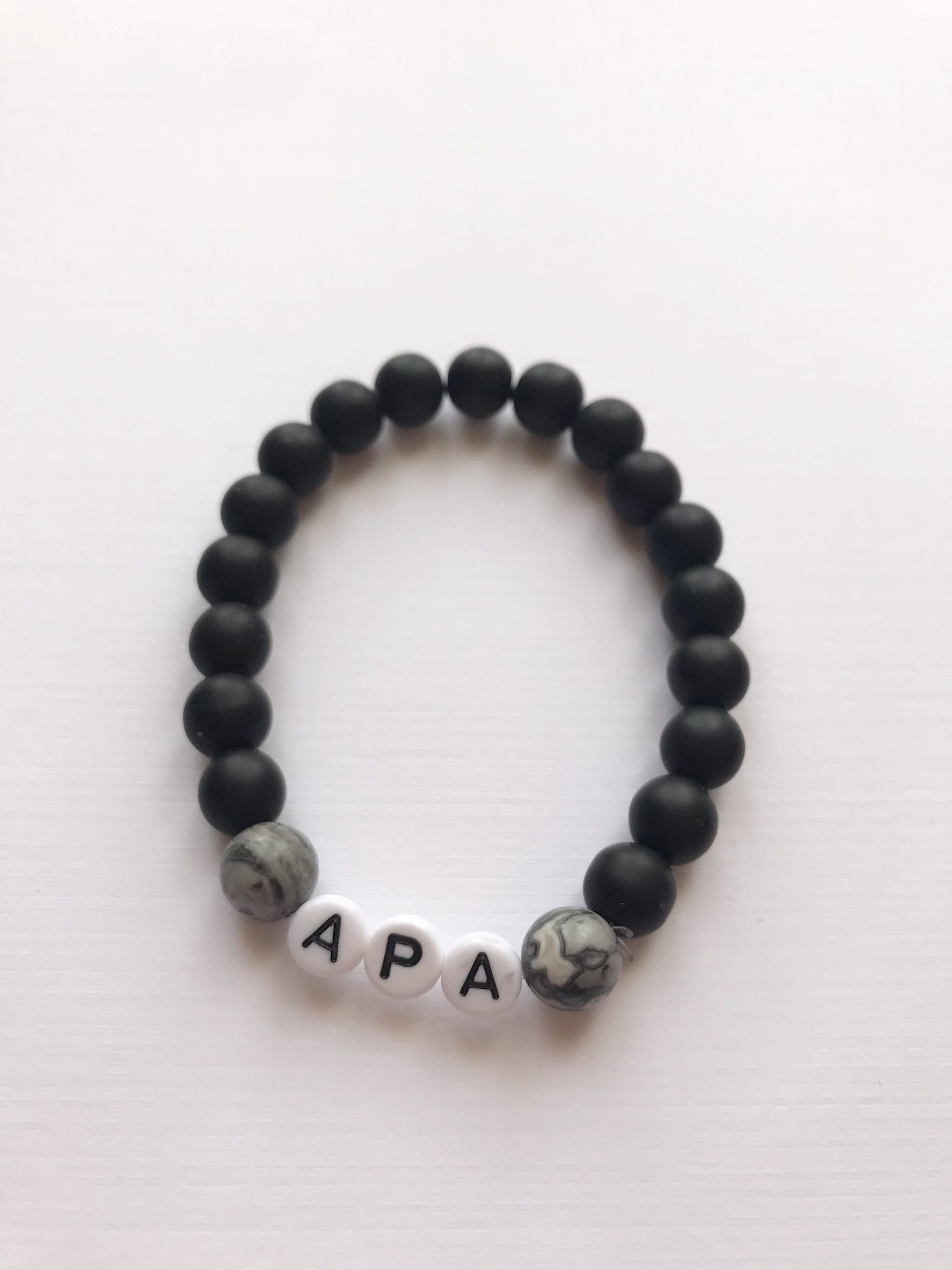 Szürke jáspis - matt ónix karkötő APA felirattal